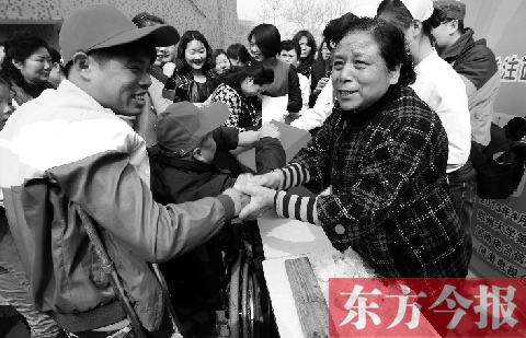 昨日，鄭大四附院的大樓前，“面人鄭”鄭玉芬（右）向前來(lái)捐款的殘疾人表示感謝