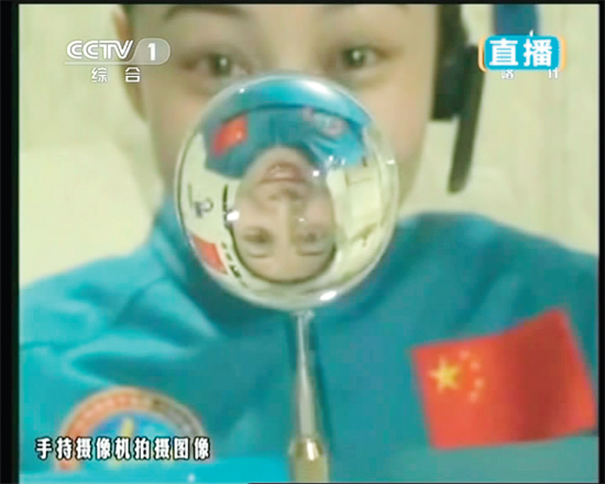 王亞平的倒影出現(xiàn)在水球中。新華社發(fā)（視頻截圖）