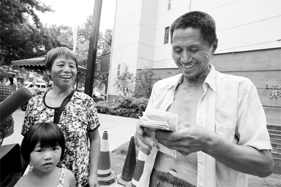 昨日，鄭州市明達(dá)路與豐慶路交叉口西300米路南，來(lái)自中牟的瓜農(nóng)拿到西瓜款，笑開顏東方今報(bào)記者袁曉強(qiáng)