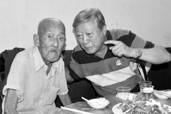 昨日，來自北京的英雄后代胡冠軍（右）專門趕到西平縣看望抗戰(zhàn)老兵孫殿修老人