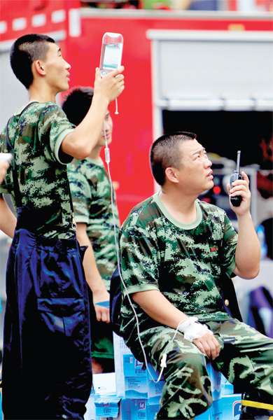 火場外，被消防戰(zhàn)士稱為“李大隊”的救援人員掛著吊瓶現(xiàn)場指揮