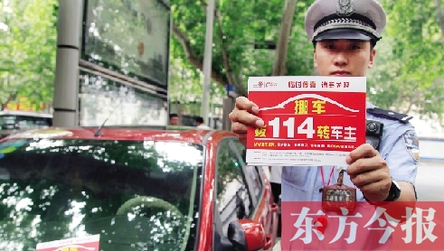 8月27日，鄭州市緯一路與經(jīng)七路交叉口，交警將“挪車請撥打114轉(zhuǎn)車主”的提示牌放在路邊?？康能嚿? width=