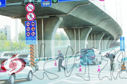 交警在東風路從北向南上橋口處擺上反光錐，間歇放行