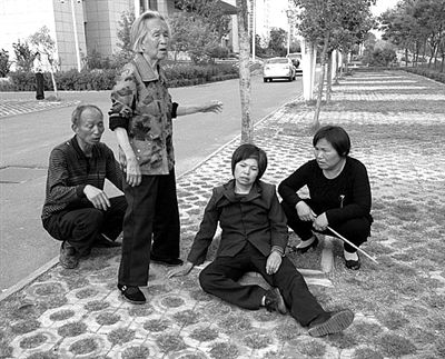 2013年4月28日，平頂山市市政府附近，受害者郭小蕊（化名）的家屬鳴冤，郭小蕊的母親杜玉花癱坐在地上。