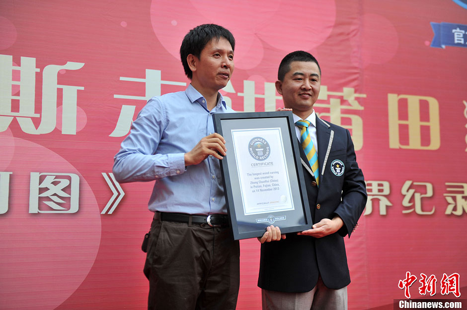 圖為世界吉尼斯認(rèn)證官為鄭春輝（左）頒發(fā)證書。呂明 攝