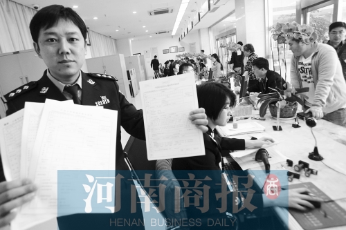 　民警左手拿的是新申請表，右手拿的是三份老申請表 王春勝/攝