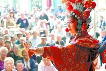 圖為8月15日戲曲演員在“流動舞臺車”上表演傳統(tǒng)地方戲《穆桂英下山》。