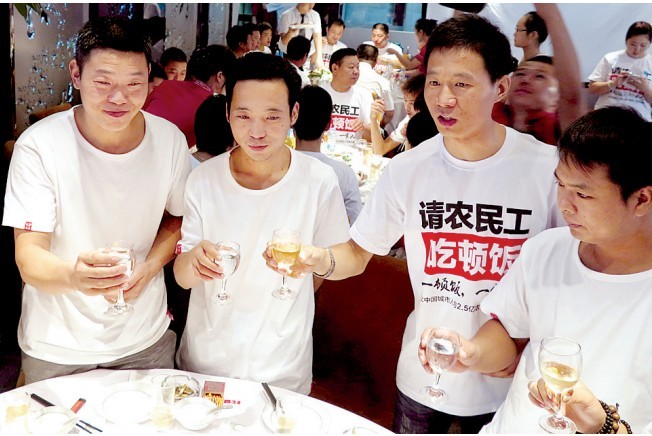 活動發(fā)起人張楠（右二）給農(nóng)民工敬酒。