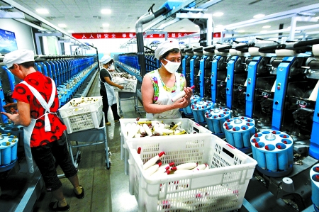 6月6日，舞鋼市鑫海紡織有限公司員工正在新建成的紡紗車間生產(chǎn)。