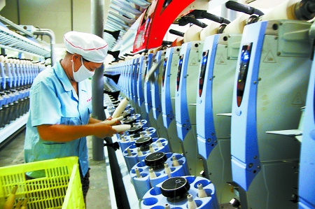 7月3日，在鄧州市永泰棉紡有限公司電腦控制全自動(dòng)紡紗車間，紡織工人正在生產(chǎn)棉紗。