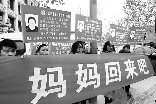 張慧媛老人的子女們舉著尋找母親的牌子和橫幅，在冷風(fēng)中呼喊著“媽媽，您快回來吧”。