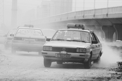 施工的道路上，車輛通過(guò)塵土飛揚(yáng)。