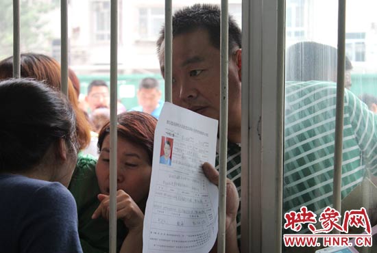 不少家長擠在報名窗口前咨詢報名事宜。