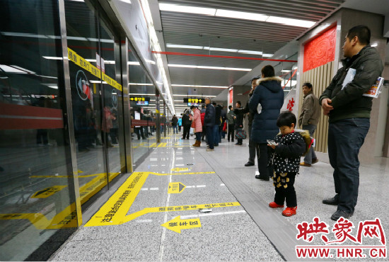 小朋友在等候區(qū)內(nèi)等待地鐵。