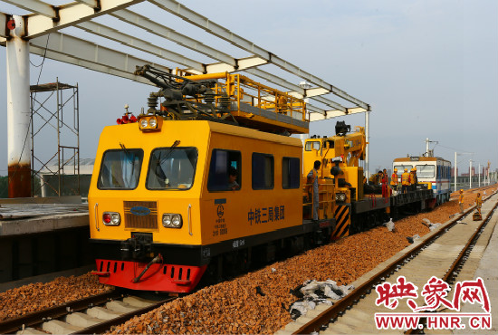 一列工程車從站臺駛過。