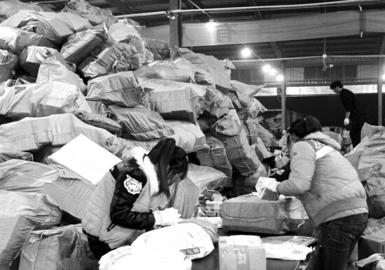 “雙十一”過后快遞業(yè)迎來投遞高峰，鄭州一家快遞公司網(wǎng)點內，快遞堆積如山，分揀員24小時不間斷工作