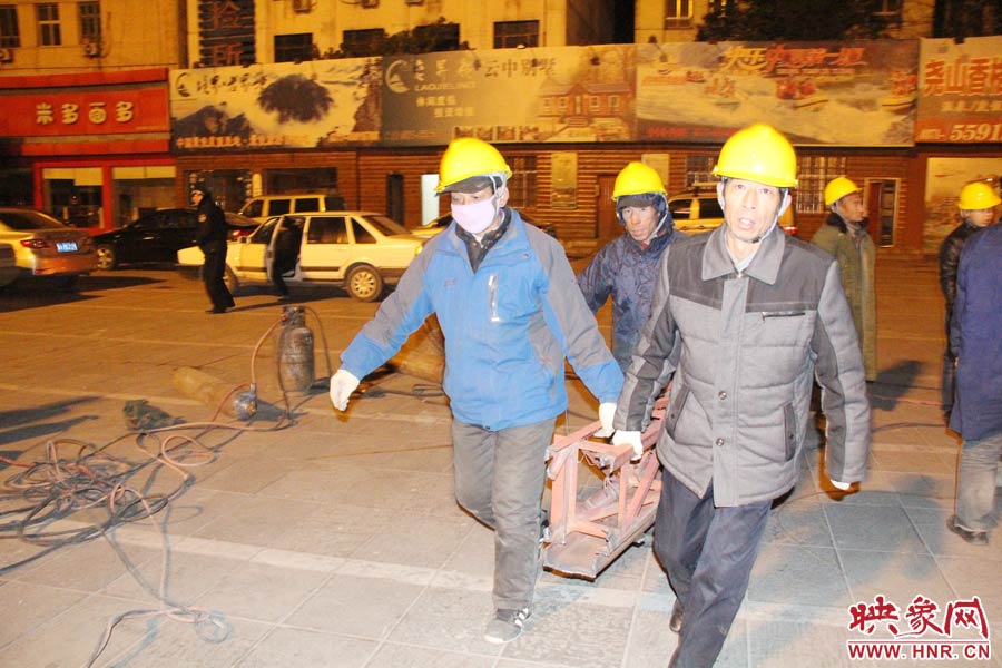 23點(diǎn)56分，第一塊兒廣告牌已經(jīng)分割完畢，地面上的20多名工人將拆除下來的鋼件撞車運(yùn)走。