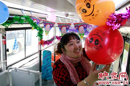 鄭州快速公交B3區(qū)間線車長李鵬云在車廂里懸掛氣球，布置圣誕車廂，營造歡樂圣誕氛圍