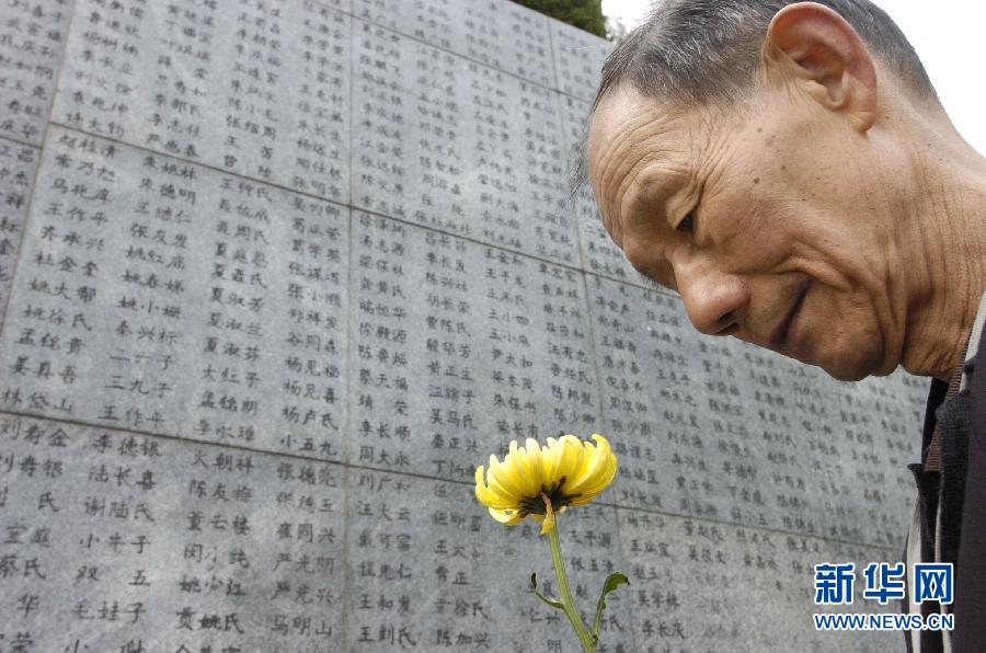 2006年4月5日，74歲的南京大屠殺幸存者佘子清手捧鮮花，祭奠被日軍殺害的母親。