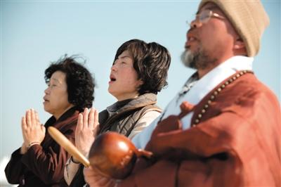 23日，一名僧侶引領(lǐng)人們?yōu)樗勒咂矶\。