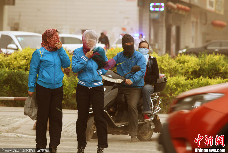 2014年04月23日，新疆維吾爾自治區(qū)吐魯番地區(qū)，市民戴著口罩行走在大風沙塵中的吐魯番市街頭。