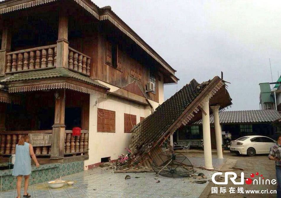 當(dāng)?shù)貢r(shí)間2014年5月5日，泰國(guó)清萊，一名婦女看著受損的房屋。 圖片來(lái)源：東方IC