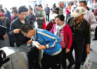去年5月5日，14號線園博園站，乘客刷卡出地鐵。北京公交地鐵將實行計程票制，多乘坐多付費。