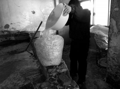 作坊內(nèi)工人用攪拌有漂白粉的藥水給豆芽增白。