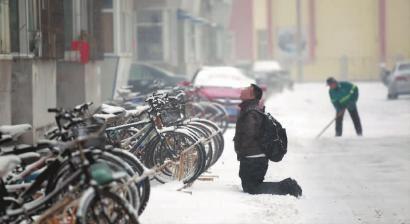 小伙子跪在樓前，一直抬頭看著樓上。 孫立國(guó)/攝