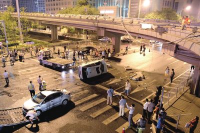 路虎沖下國貿(mào)橋砸中一輛起亞轎車，橋上厚達(dá)幾十厘米的水泥護(hù)欄被撞斷，碎石四處散落，數(shù)十群眾在現(xiàn)場圍觀。