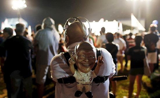 9月4日，新加坡，執(zhí)政黨的一場集會上，一名支持者背著一個李光耀的人偶。