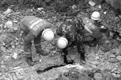 搜救人員正在用探視儀器觀看被掩埋層的情況。