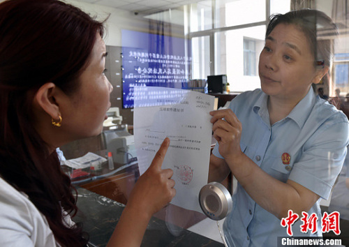 資料圖：2015年5月4日，河北石家莊市橋西區(qū)人民法院立案庭庭長齊燕正在為立案人辦理相關(guān)手續(xù)，完成整個過程只用了5分鐘。當(dāng)日是立案登記制改革首個工作日，該院共立案36件，立案率達到90%。中新社發(fā) 翟羽佳 攝