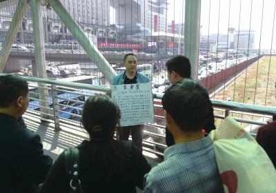 韓先生在北京西站天橋上籌錢。京華時(shí)報(bào)記者陶冉攝