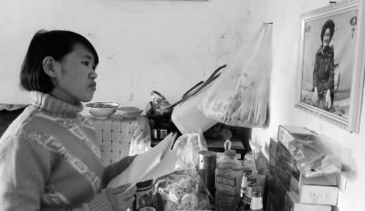 錢仁鳳站在母親遺像前。未能見母親最后一面是她的一大遺憾。