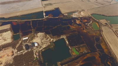 4月19日，廊坊市大城縣南趙扶鎮(zhèn)，津保路以北約八九百米處，一個巨大的污水坑中，水體呈現(xiàn)紅褐色。 新京報記者 尹亞飛 攝