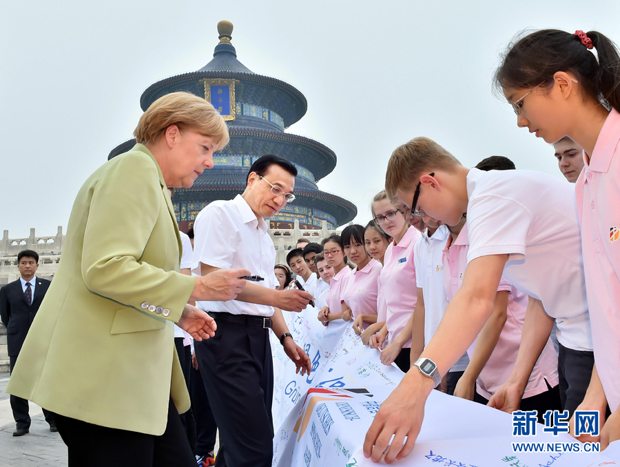 李克強同默克爾在紀(jì)念橫幅上簽名。