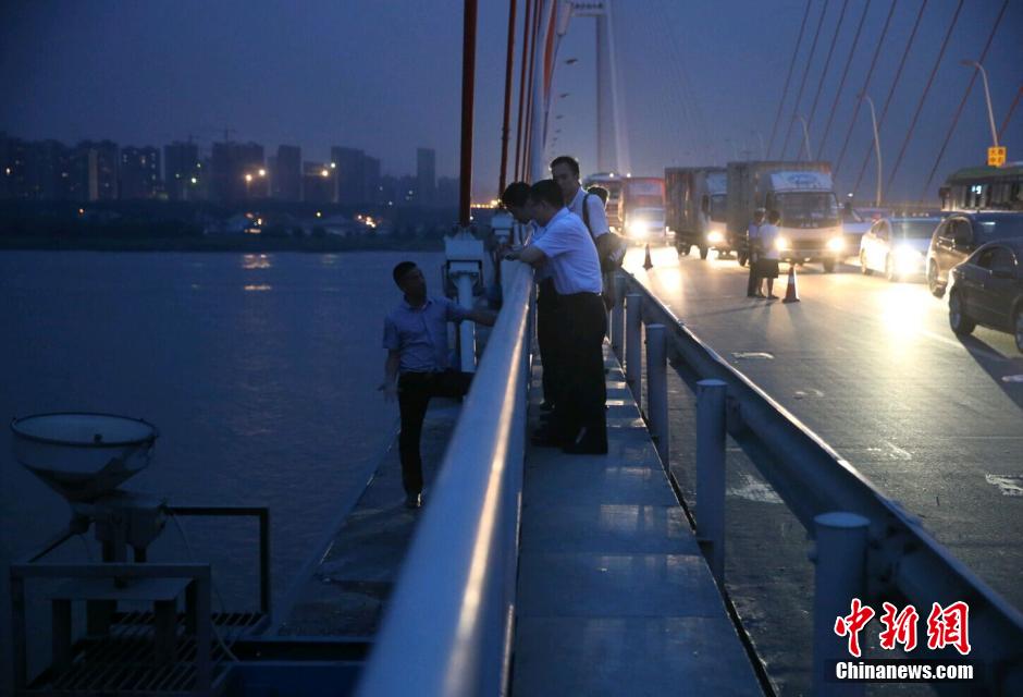 圖為武漢警方談判專家正在與翻爬至大橋外側護欄的劫持者談判。