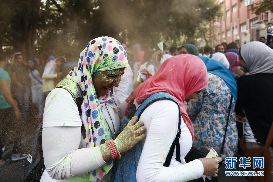 10月16日，在埃及首都開羅，兩名女青年在“彩色跑”活動(dòng)中躲避人們拋撒的彩色粉末。