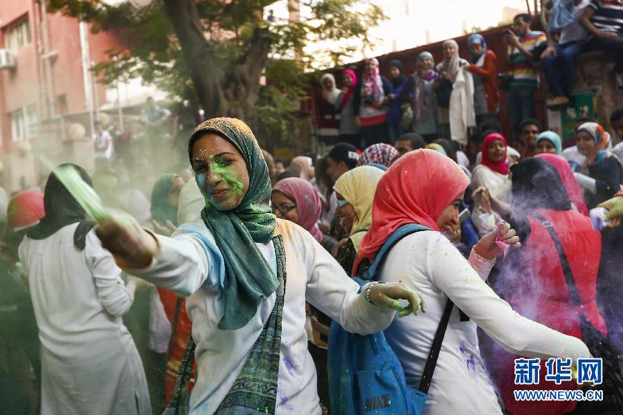 10月16日，在埃及首都開羅，一名女青年在“彩色跑”活動(dòng)中拋撒彩色粉末。