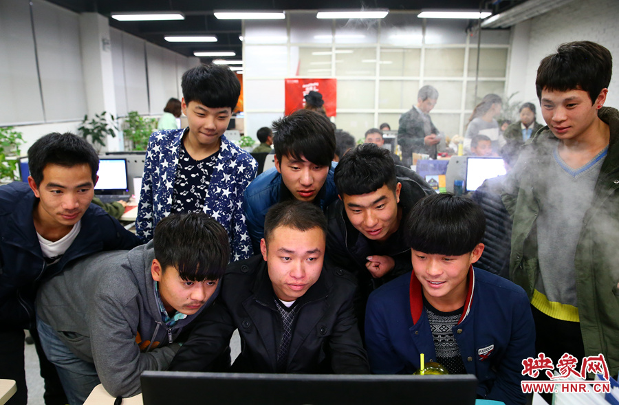 電腦前聚集了關注著銷售業(yè)績的員工