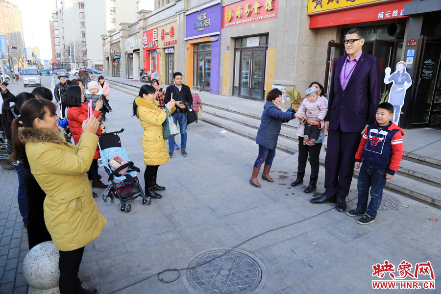 過路市民爭相與“巨人”合影。