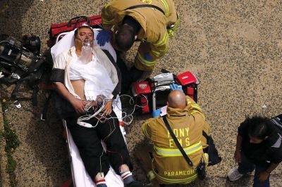 2日，救援人員在美國(guó)紐約地鐵事故車輛內(nèi)緊急疏散一名受傷乘客。圖/CFP