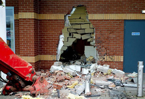 劫匪利用挖掘機(jī)的機(jī)械臂移走ATM機(jī)，留下滿地狼藉