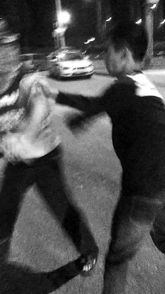 一名男子扯著民警的反光背心一路追打。