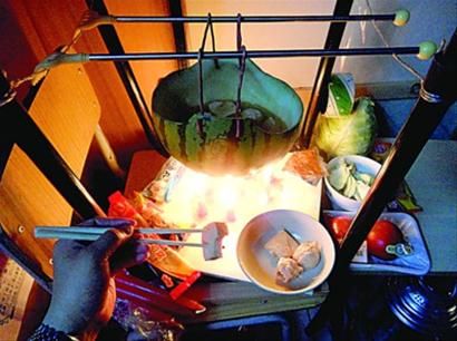 兩張椅子被面對面疊在一起，穿了兩根線的西瓜皮就懸空在椅腳中間，下面有蠟燭加熱，這就是西瓜火鍋。