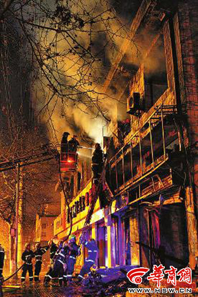 昨日22時(shí)10分，西安市豐慶路南小巷南口，消防官兵架梯子登上二樓施救 本組圖片由本報(bào)記者 閆文青 攝