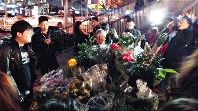 昨晚7時(shí)許，三里屯太古里西邊附近一過街天橋旁邊，聞?dòng)嵍恋木W(wǎng)友圍住了賣花老人，爭相買花。 網(wǎng)友“行者橙子”供圖