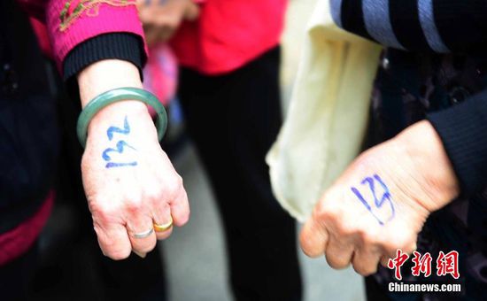 圖為10月28日，在江西九江市一家羊絨皮草服裝服飾博覽會(huì)現(xiàn)場(chǎng)，老人們正在頂著寒風(fēng)排隊(duì)等待領(lǐng)取10元代金劵。