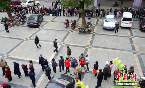 圖為10月28日，在江西九江市一家羊絨皮草服裝服飾博覽會(huì)現(xiàn)場(chǎng)，老人們正在頂著寒風(fēng)排隊(duì)等待領(lǐng)取10元代金劵。